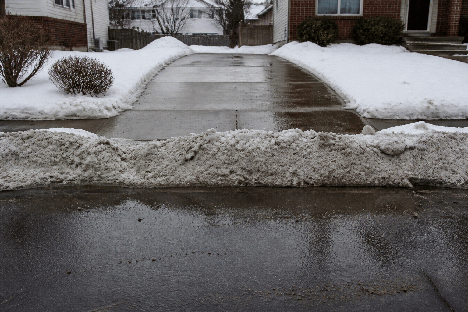 Snow pile left at a driveway mouth after a city street plow